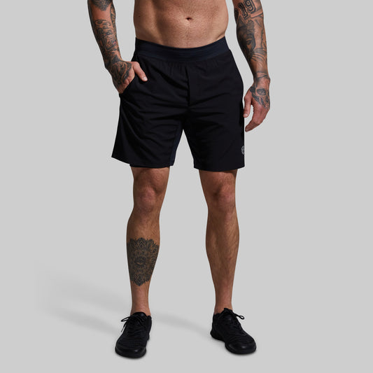 Person wearing black shorts on a gray background