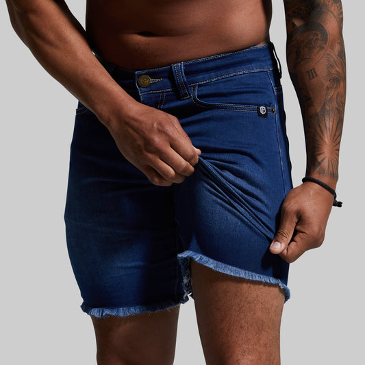 Person wearing blue denim shorts on a plain background